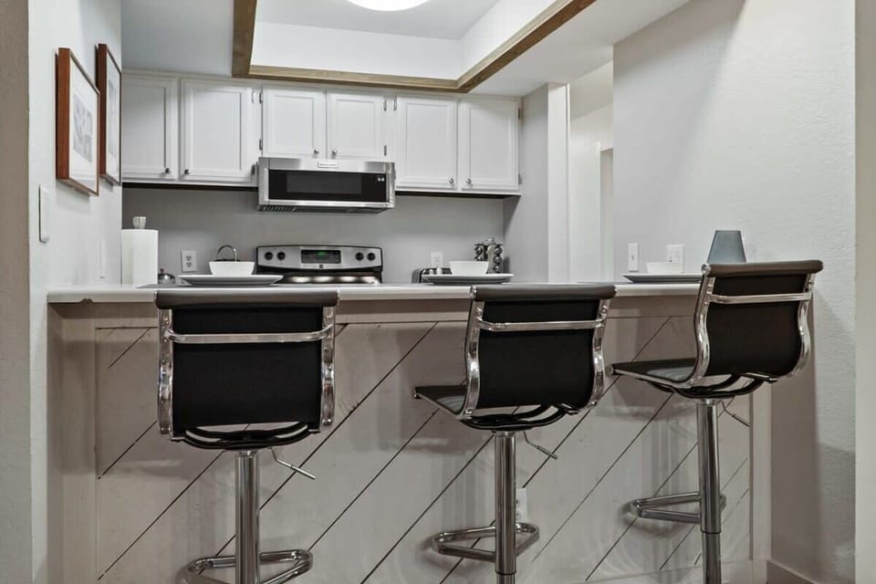 The fully equipped kitchen has everything you need to prepare a delicious meal including spacious white countertops, a large pantry, and a kitchen bar with 3 bar stools.