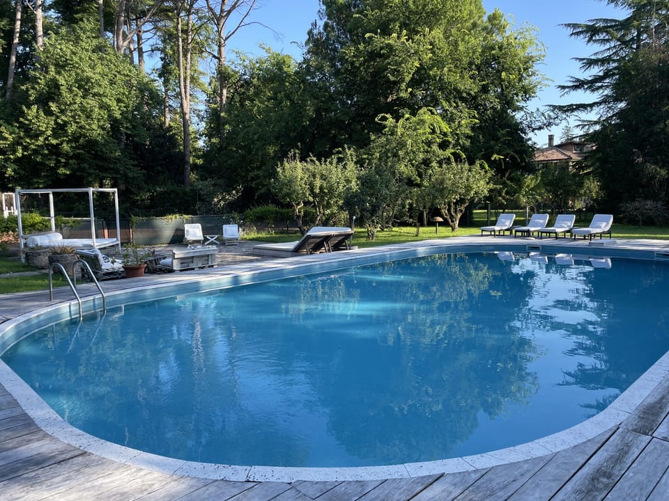 The big mosaic Swimming Pool with sunbeds and kiosk w/ kitchen, sofa and a table