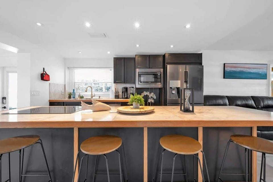 Experience this inviting and fully operational kitchen space. Delight your friends and family with its up to date layout, featuring a spacious two-door fridge, and a beautifully crafted island tabletop.