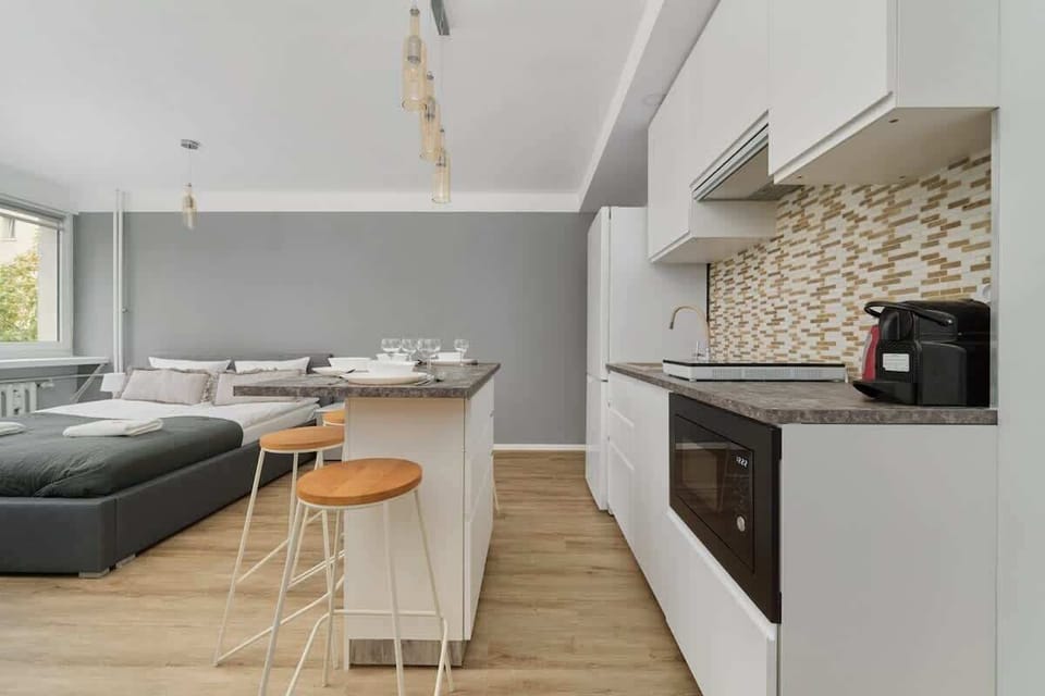 A bright open-concept space combining the kitchen, dining, and living areas in a modern design.
