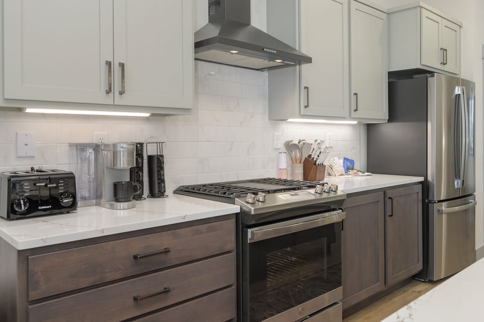 Cook your favorite meals in this modern kitchen featuring stainless steel appliances, granite countertops, and all the tools you need.