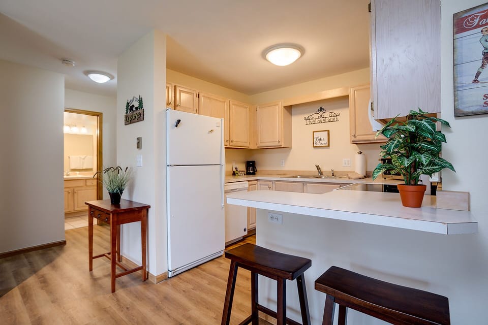 Your bright kitchen awaits with full appliances and breakfast bar - perfect for morning coffee or preparing meals during your stay.