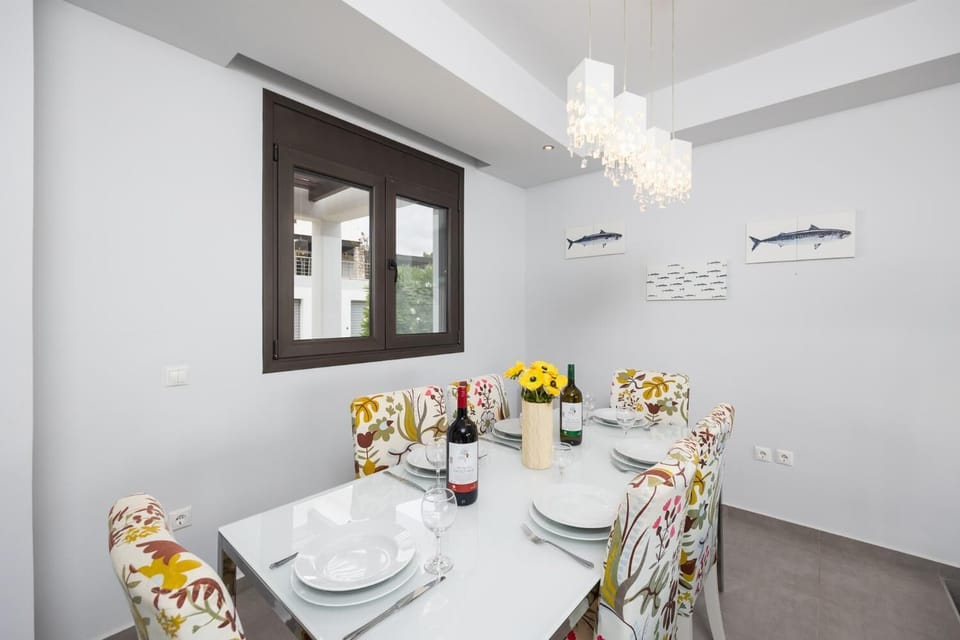 Open-plan living room with sofas, dining area, kitchen, ornamental fireplace, A/C, WiFi internet, satellite TV, and sea views