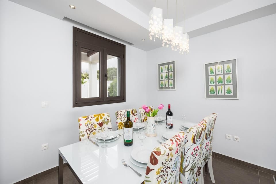 Open-plan living room with sofas, dining area, kitchen, ornamental fireplace, A/C, WiFi internet, satellite TV, and sea views