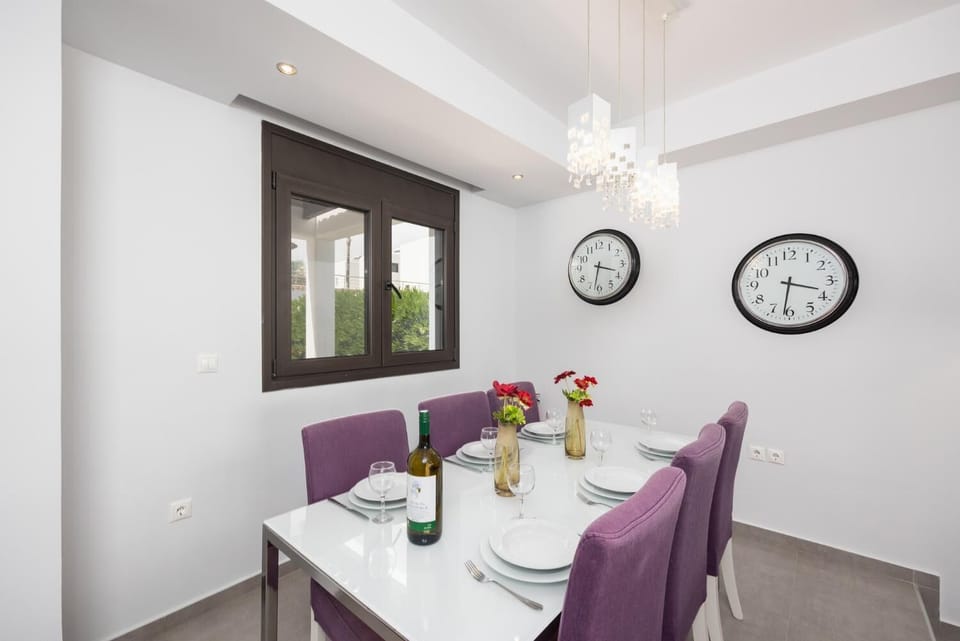 Open-plan living room with sofas, dining area, kitchen, ornamental fireplace, A/C, WiFi internet, satellite TV, and sea views