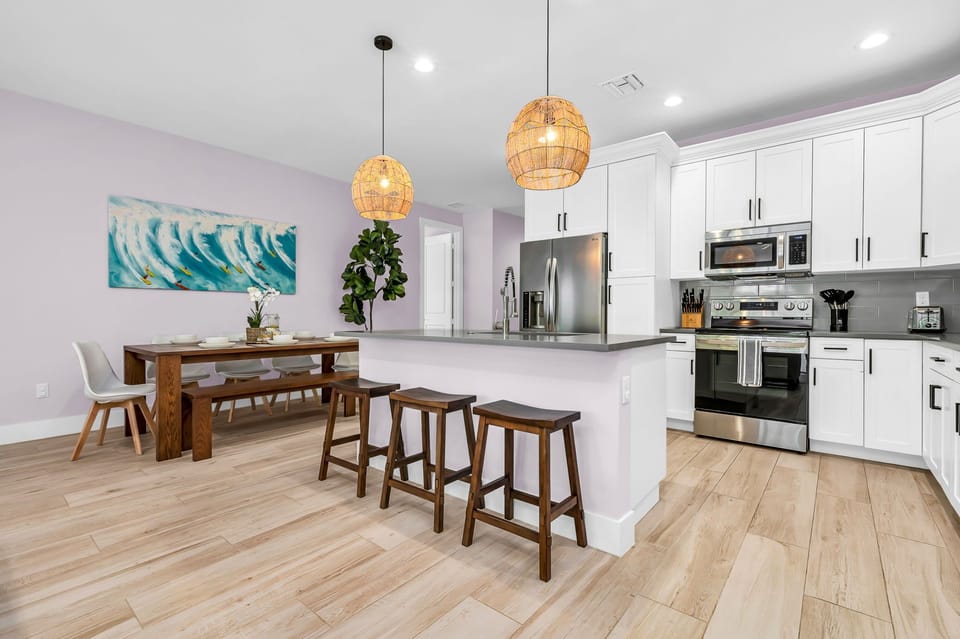 This dining space seamlessly integrates with the open-plan kitchen, making it easy to transition from cooking to dining. Additional bar stool seating at the kitchen island allows for extra dining space.