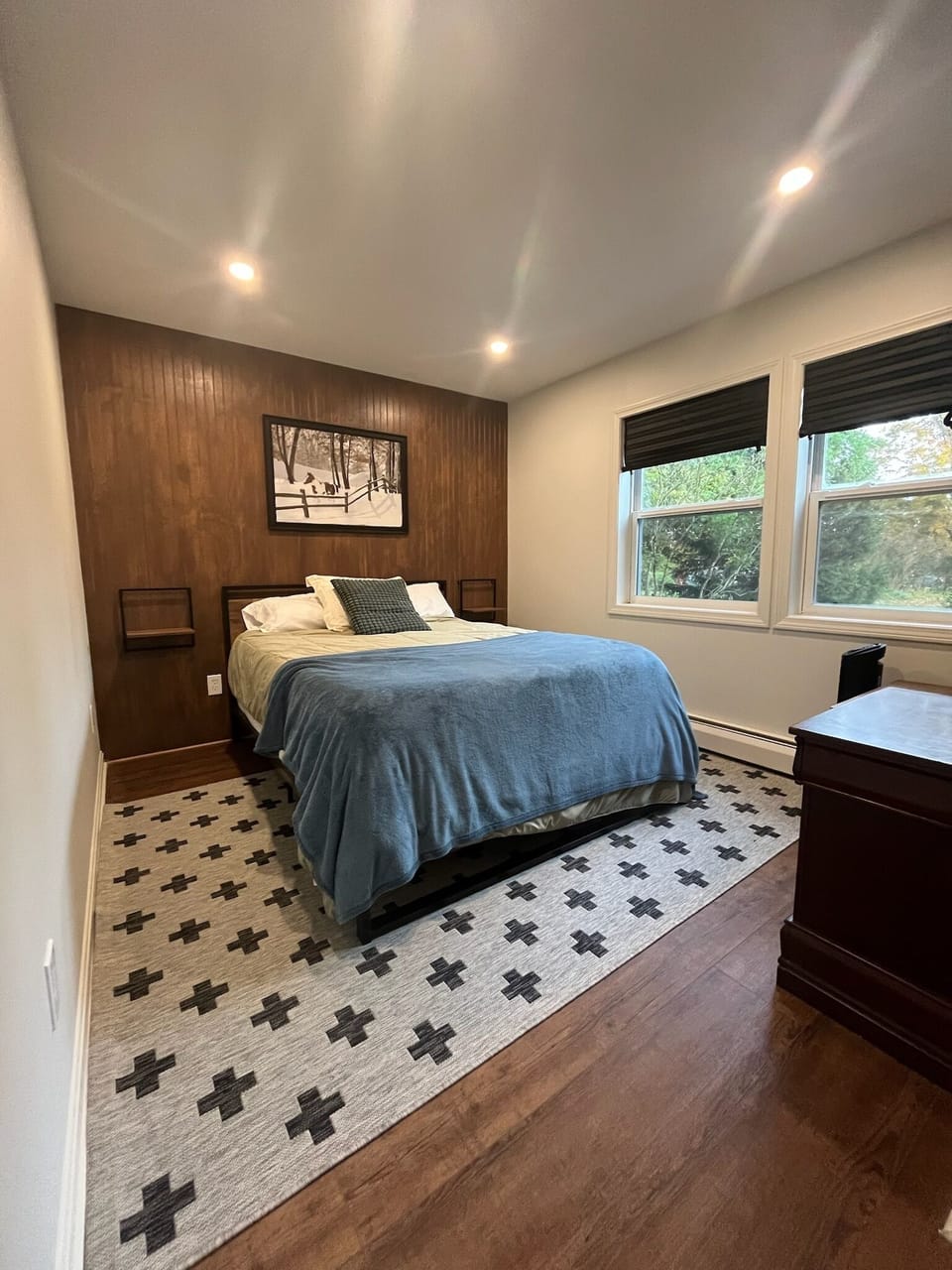 Front bedroom with queen bed, side tables, hanging bar for clothes, luggage rack