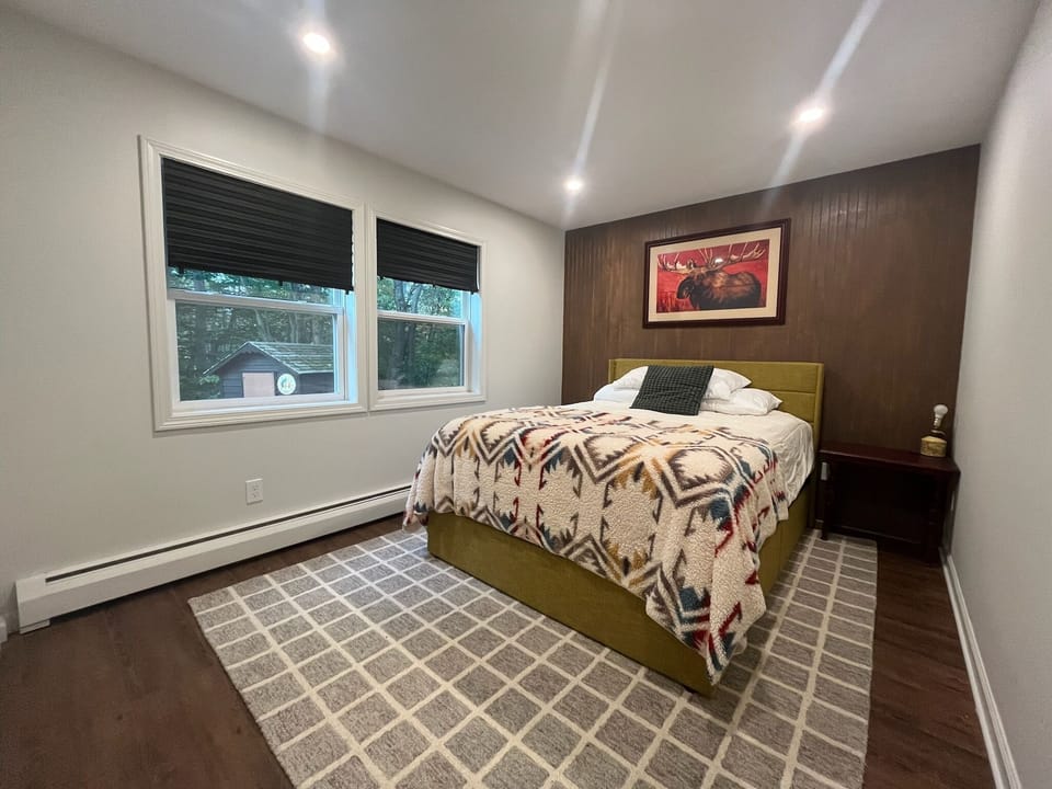 Main bedroom with queen bed, large closet and end tables. View of backyard