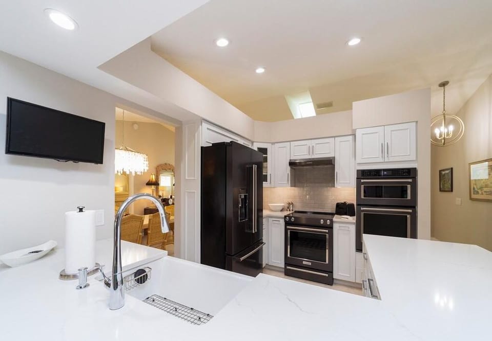 Black stainless steel appliances include a double oven, stove with vent hood, and French-door refrigerator.