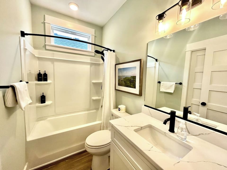 Modern bathroom with fresh towels and bath essentials provided.