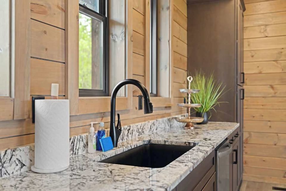 A deep, modern sink paired with sleek black fixtures offers both functionality and contemporary style in this kitchen space.