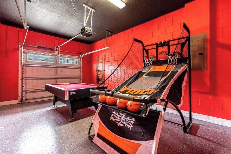 The garage has been transformed into a dynamic recreational space, showcasing a blend of sports and entertainment. A basketball hoop, and a billiards.