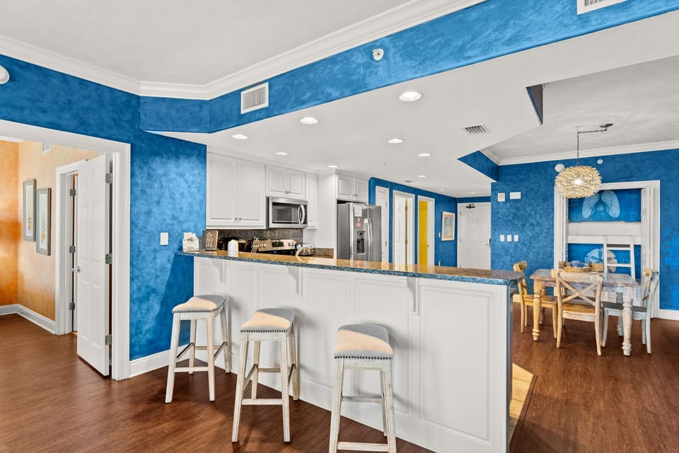 Your open kitchen features vibrant blue walls and a spacious island perfect for cooking together and casual dining.