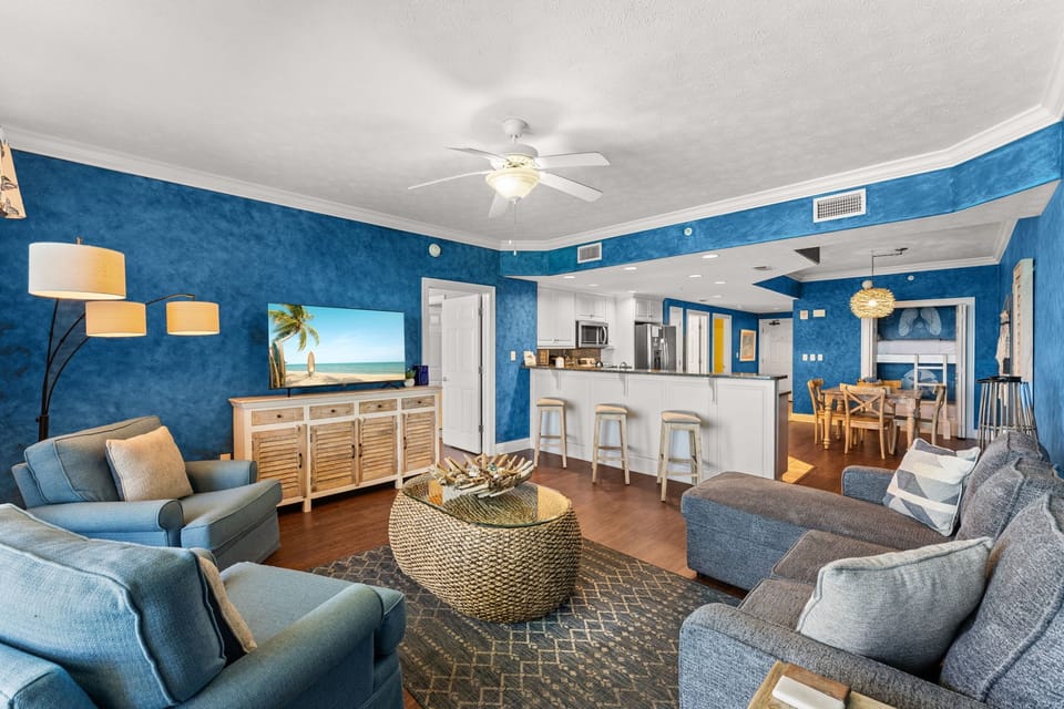 Unwind in your ocean-themed living space with plush seating and modern kitchen for memorable beach getaways.