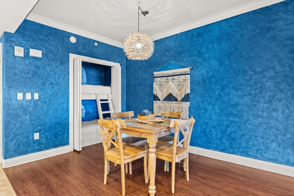Gather around this charming rustic table where vibrant blue walls create a cozy atmosphere for your meals and conversations.