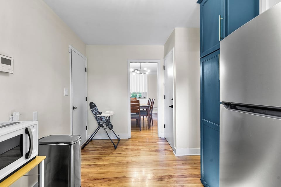 Your modern kitchen features sleek blue cabinetry and stainless steel appliances, creating a stylish cooking space that flows seamlessly into the dining area.