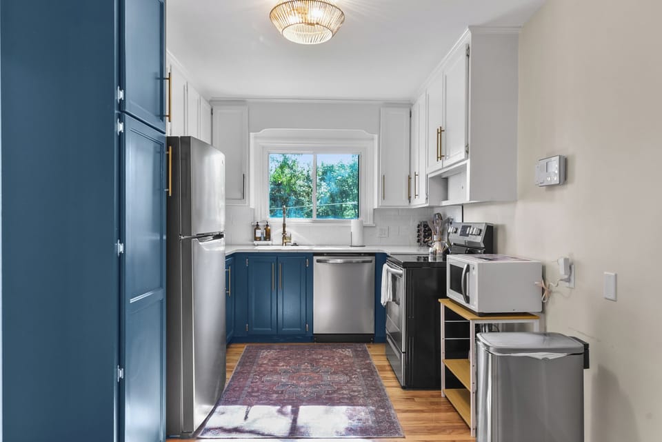 Your fully equipped kitchen features modern appliances and elegant blue cabinetry, perfect for preparing meals during your stay.