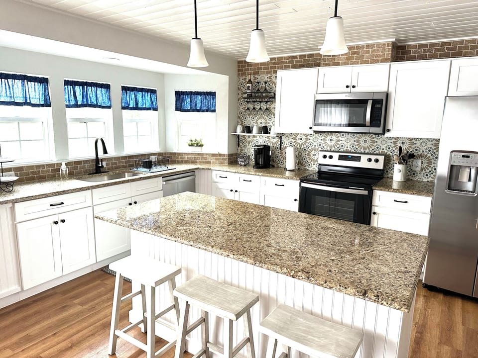 Kitchen has island seating and is open to dining and living areas