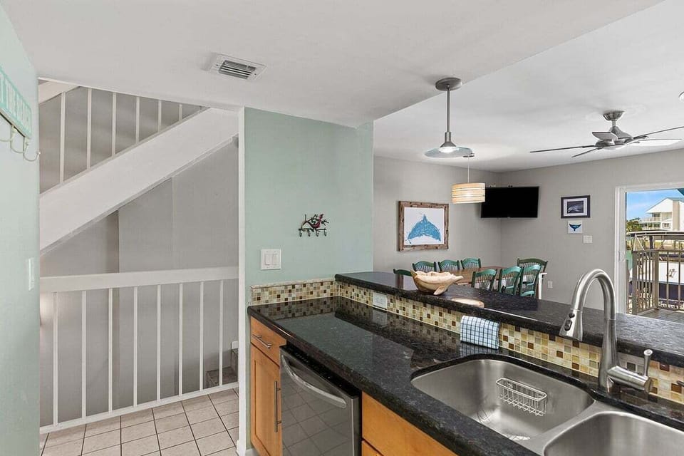 The kitchen's open layout keeps guests connected to the dining and living spaces while offering attractive granite surfaces.