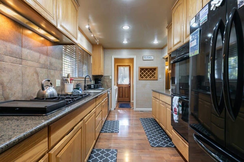 The fully equipped kitchen is outfitted with spacious countertops, a double oven, and a range of kitchenware and small appliances.
