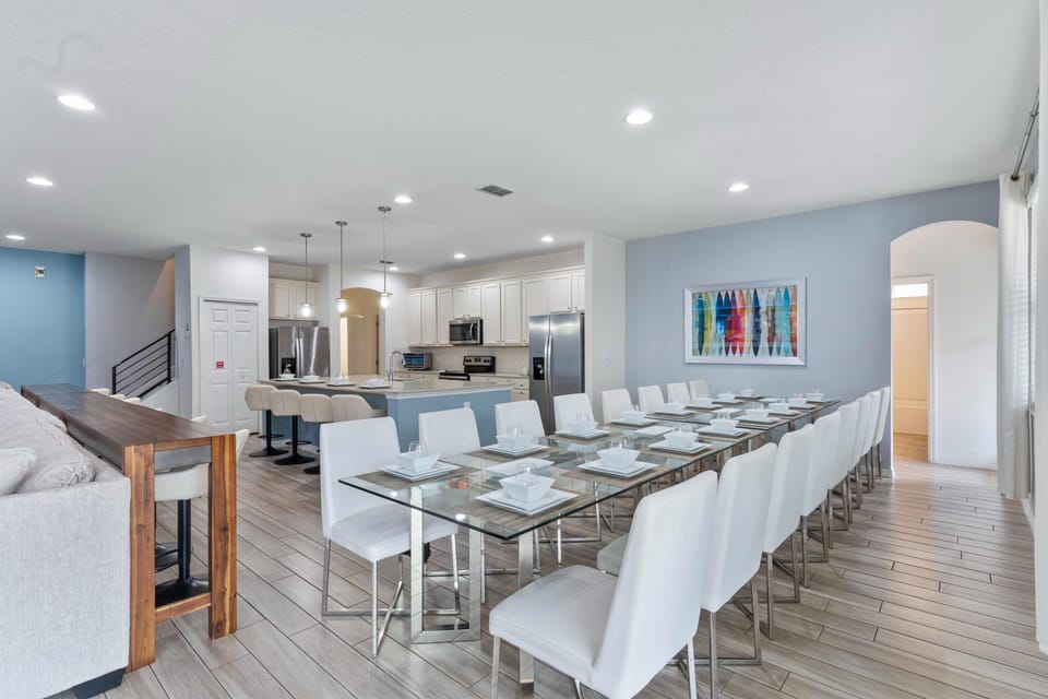 - Dining room with long glass tables set for group dinners  
- Open plan connects easily with kitchen and living room  
- Perfect for gatherings meals family reunions and events