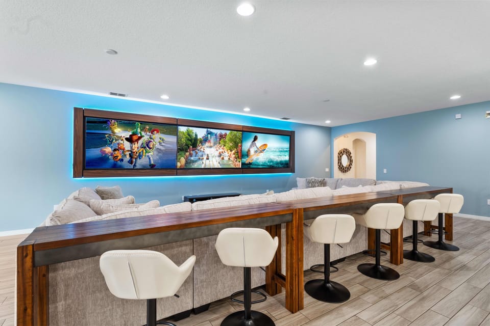 - Lounge area with bar seating and wall screens for fun nights  
- Comfortable sectional sofa for family friends and group fun  
- Open living space designed for shared entertainment