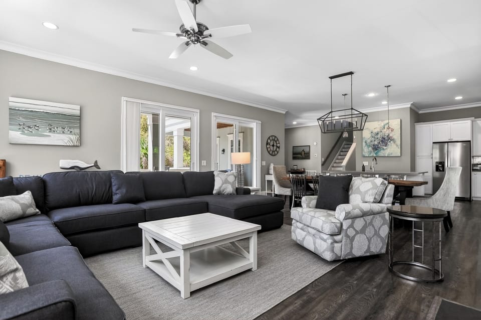 Bright and welcoming living room with multiple sofas, a fireplace, and a TV.