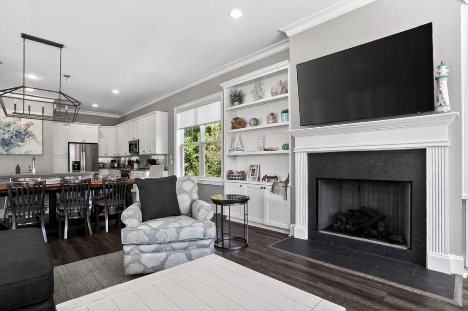 Bright and welcoming living room with multiple sofas, a fireplace, and a TV.