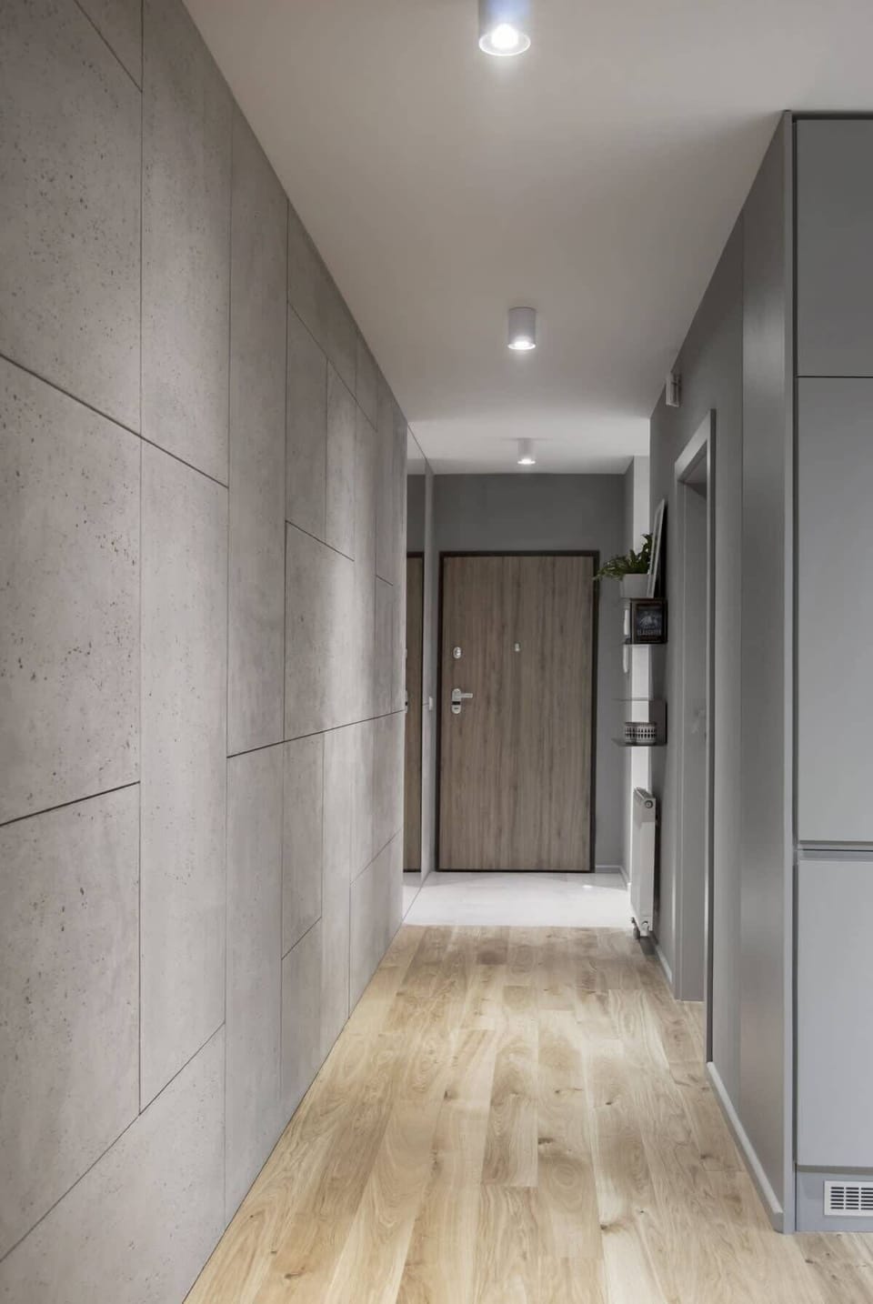 The entrance area with wooden doors, a tiled floor, and stylish shelving for decorative storage.
