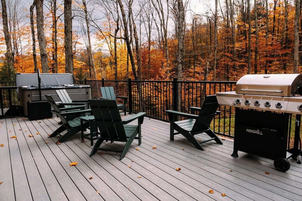 Deck with a premium hot tub, adirondack seating, grill and views of the VT woods.