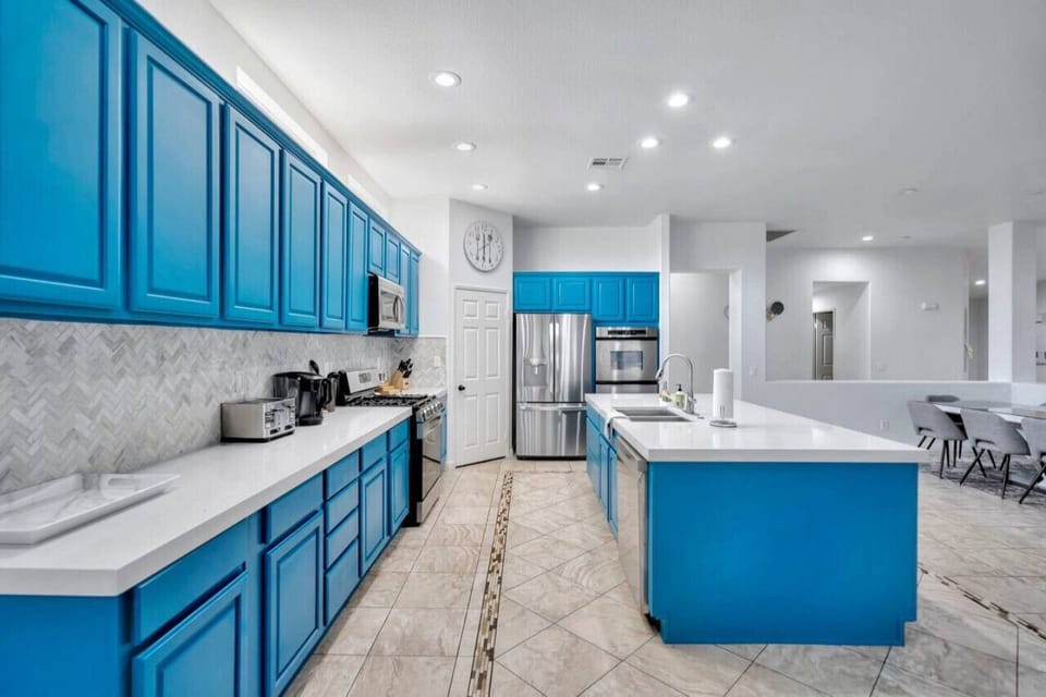 Modern kitchen featuring vibrant blue cabinetry, spacious countertops, and elegant details.