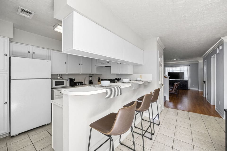 Open-concept kitchen with breakfast bar seating and easy flow into the living area