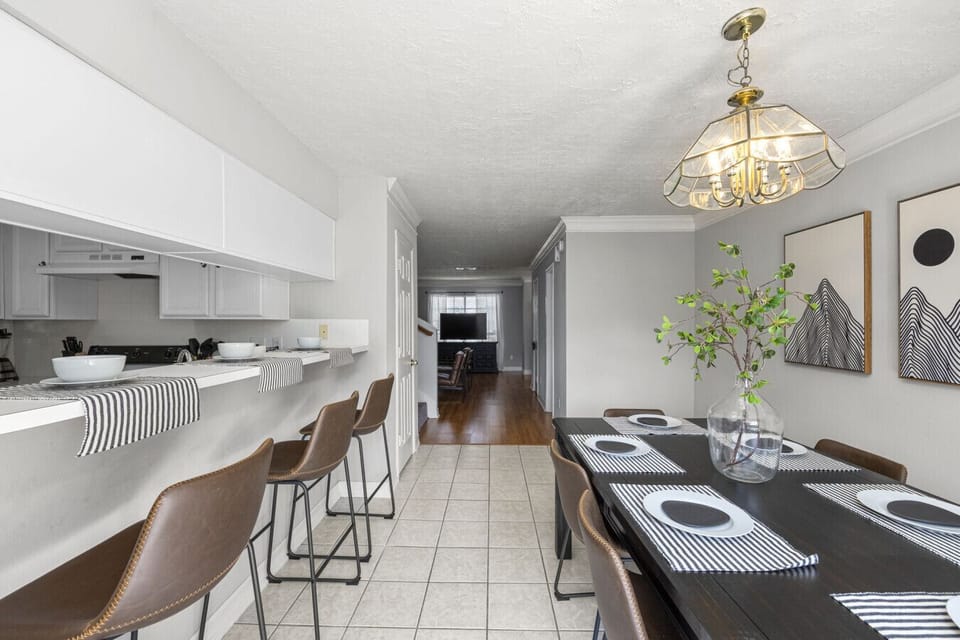 Dining area with island bar seating and open sightlines to the living room