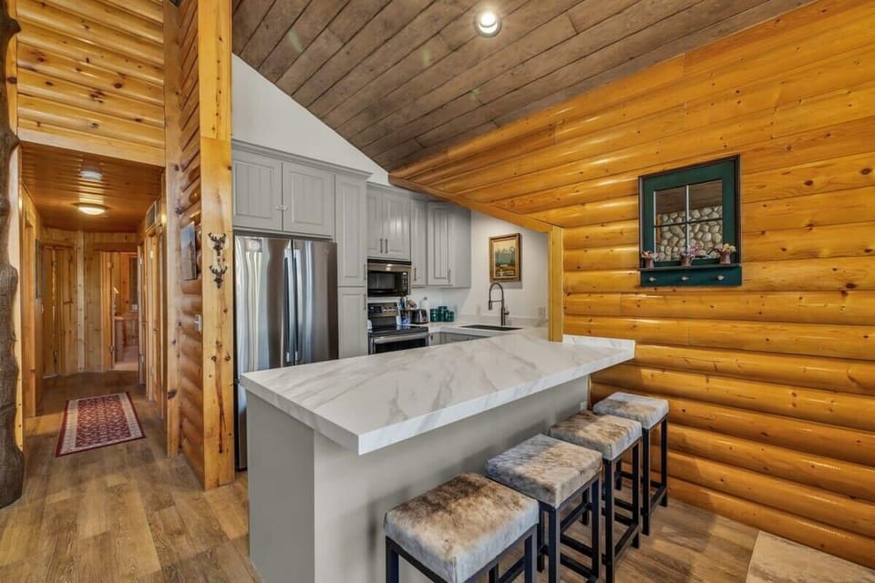The gourmet kitchen is a highlight of the home with high-end stainless steel appliances, beautiful marble countertops, and a spacious kitchen bar with four bar stools.