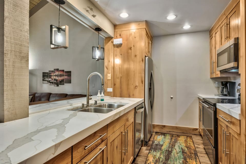 Your gourmet kitchen features warm wood cabinets, marble countertops, and modern appliances for memorable meal preparation.