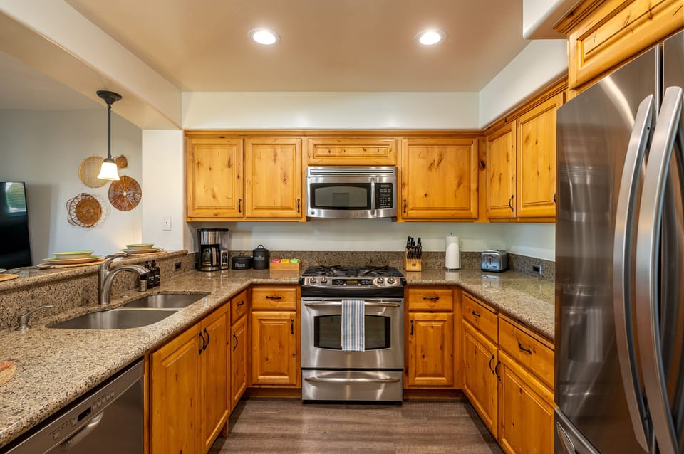 Full kitchen features a bar w/ seating for four, coffee maker, cooking essential