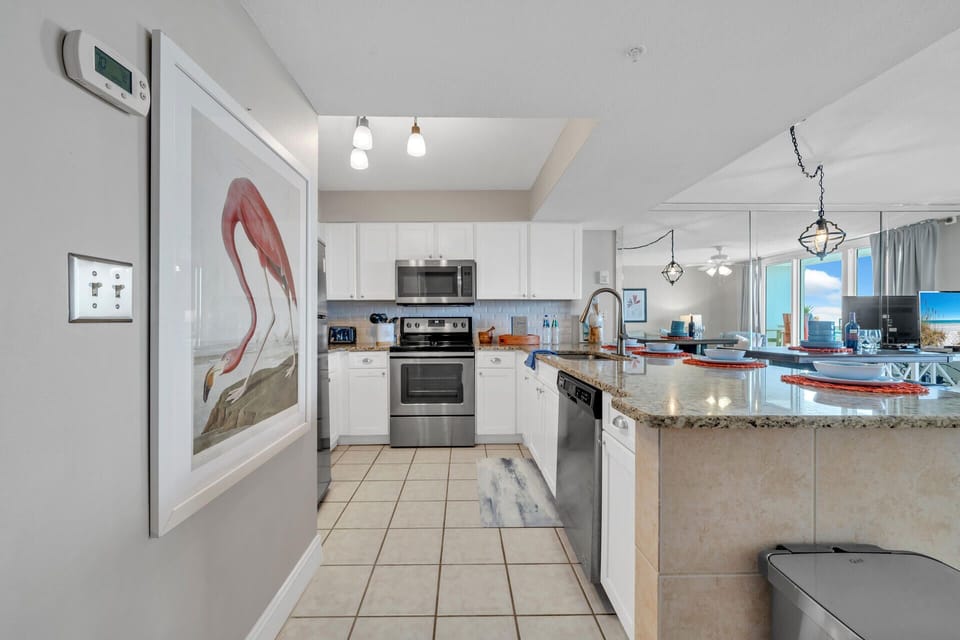 Your fully equipped kitchen features granite countertops, stainless steel appliances, and stunning ocean views through floor-to-ceiling windows.