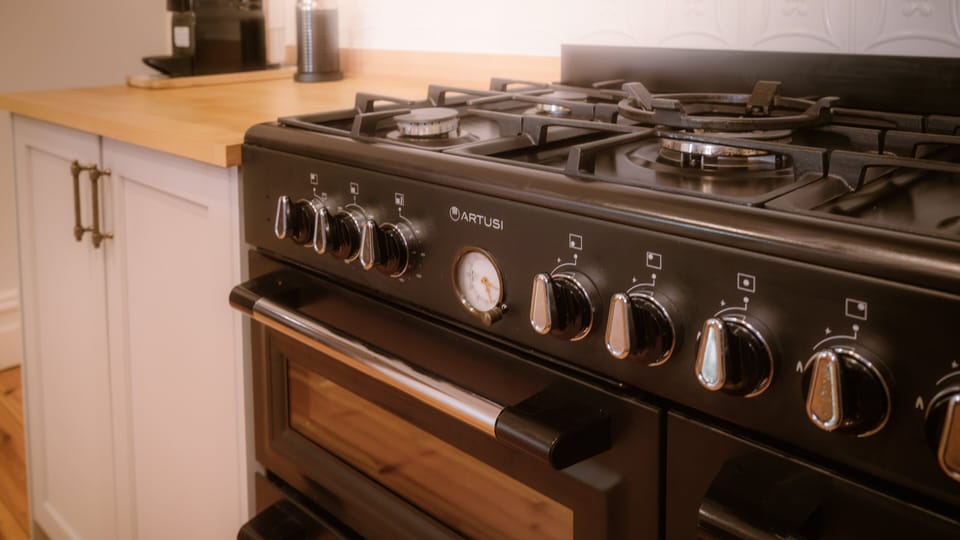 Farmhouse style kitchen with gas cooker and featuring antique wood fired cooker