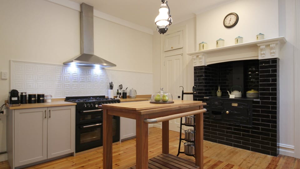 Farmhouse style kitchen with gas cooker and featuring antique wood fired cooker