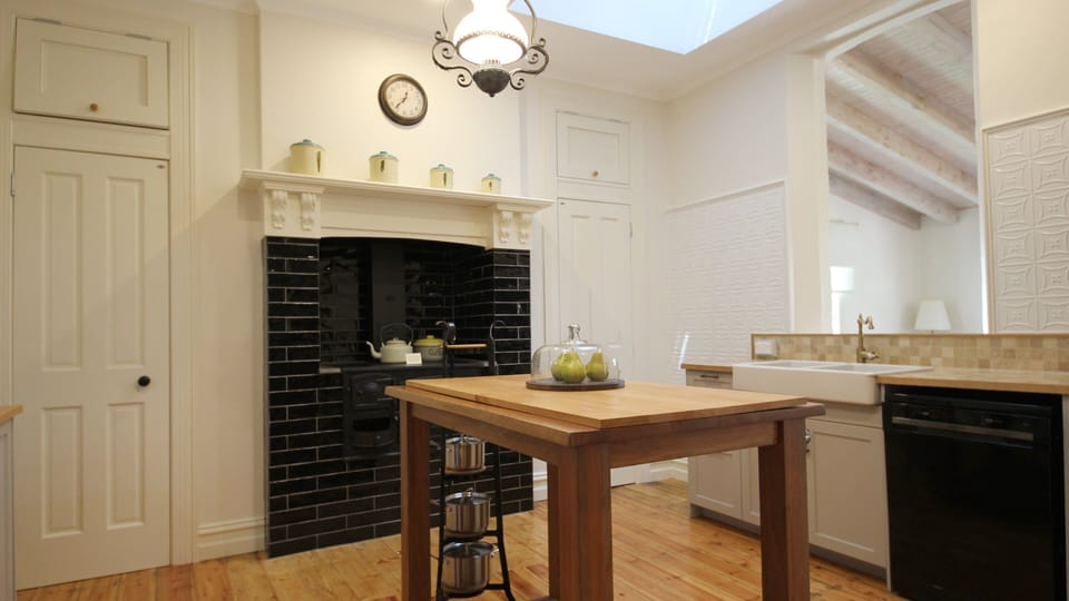 Farmhouse style kitchen with gas cooker and featuring antique wood fired cooker