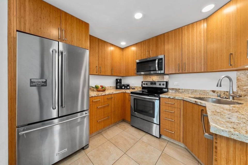 Modern kitchen with stainless steel appliances — granite counters and sleek wood cabinetry for effortless cooking.
