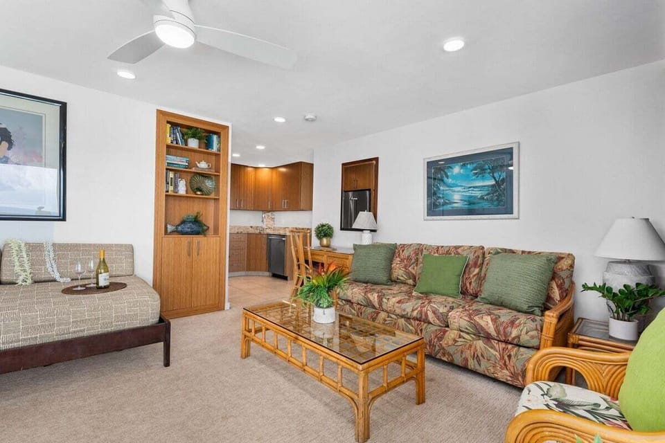 Inviting living room with island charm — floral sofa, built-in shelving, and soft lighting for cozy evenings.