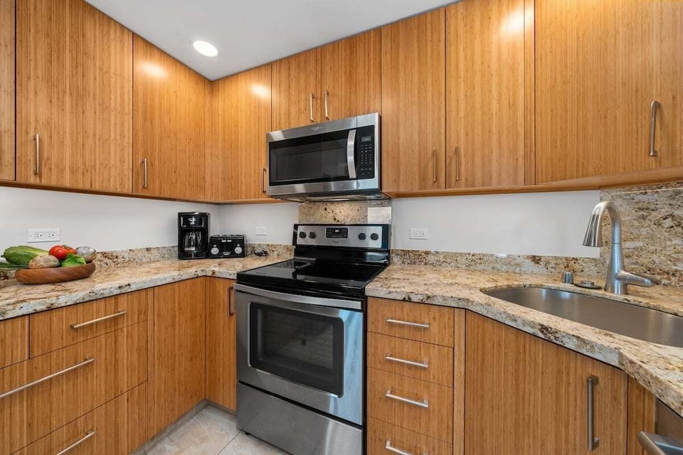 Modern kitchen with granite counters — stainless steel appliances and wood cabinetry for effortless vacation cooking.