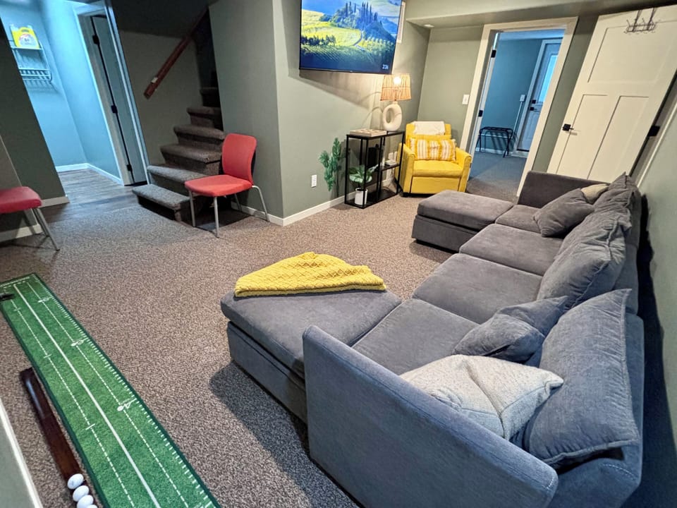 Living room featuring 55” big screen TV, indoor golf, pull out couch & sofa bed