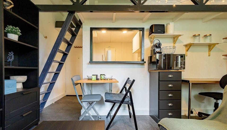 Pièce à vivre avec coin bureau, télé et canapé et quelques rangements