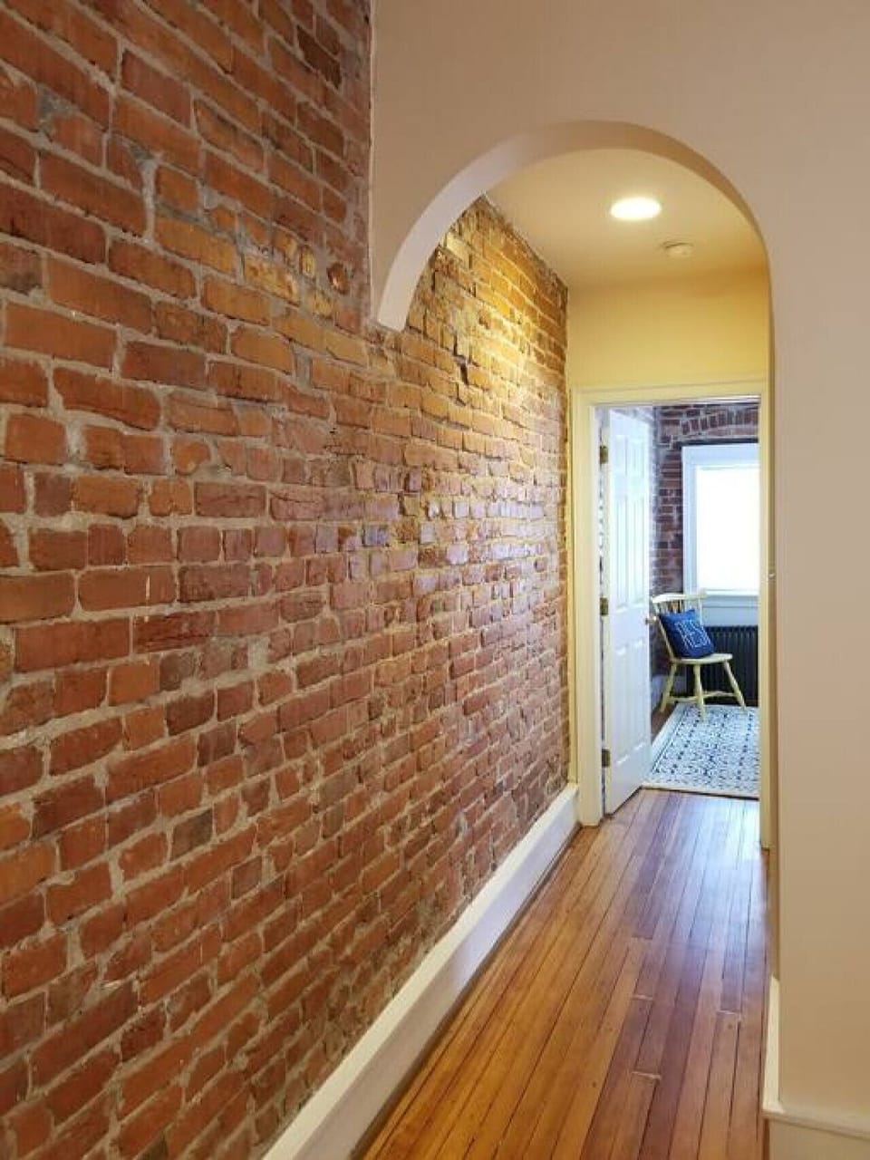 Beautiful exposed brick, hardwood floors, and curved archways give this apartment lots of charm.