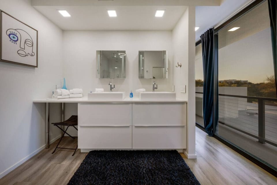 Primary bedroom`s en-suite bathroom with double vanity, walk-in shower, and tub