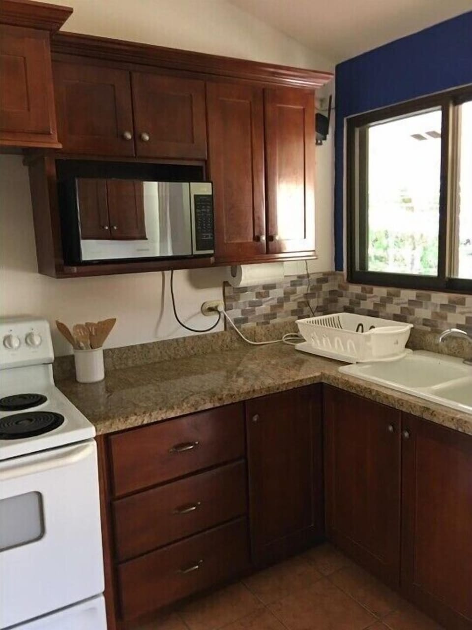 Fully stocked kitchen with refrigerator, stove, microwave.