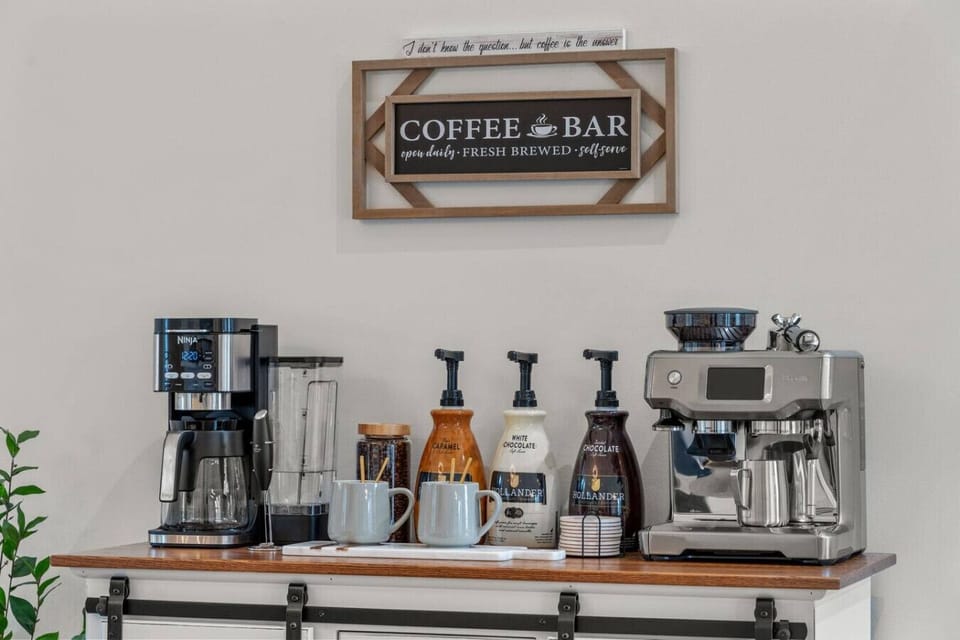 A coffee bar with kcups, espresso machine and flavored syrups.