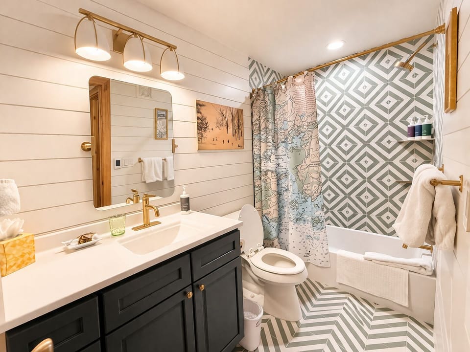 Updated full bathroom featuring stylish finishes, generous counter space, and convenient access from guest bedrooms.